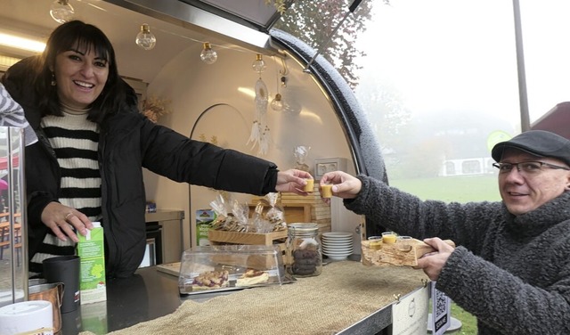 Hndlerin und Besucher stoen miteinander an.  | Foto: Heidrun Simoneit