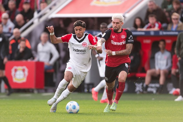 Torsch&uuml;tzen unter sich: Leverkuse...ts Omar Marmoush im Duell um den Ball.  | Foto: Marius Becker/dpa