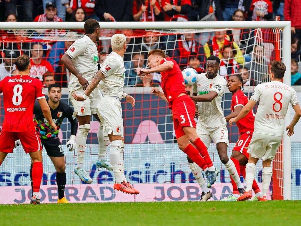 Der SC Freiburg und der FC Augsburg im Zweikampf vor dem Tor.