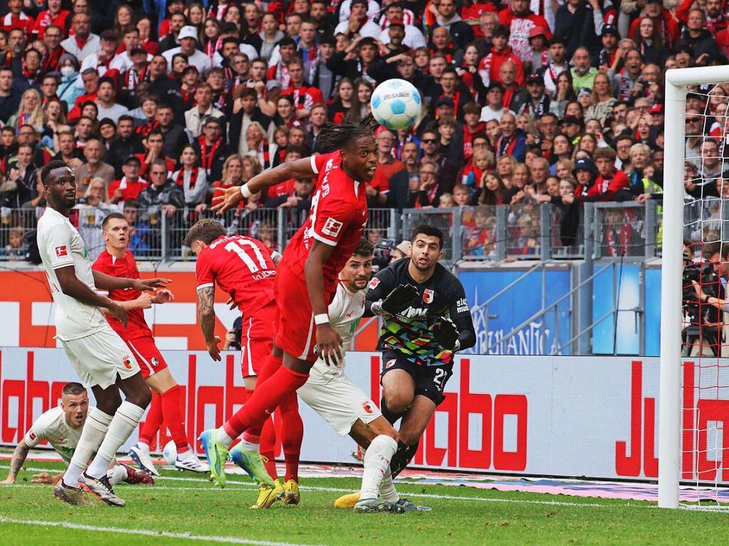 Junior Adamu kpft den Ball vor dem Augsburger Tor.