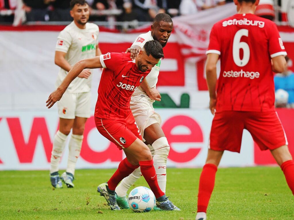 Freiburgs Vincenzo Grifo  im Zweikampf mit Augsburgs Ogochukwu Frank Onyeka.