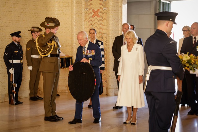 Charles und Camilla haben ihren Besuch... mit einer Kranzniederlegung begonnen.  | Foto: Brook Mitchell/Getty Images Pool via AP/dpa