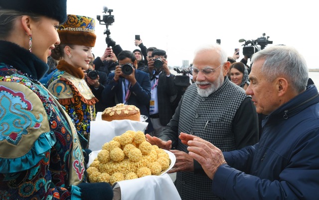 Der indische Premierminister Narendra ...nelle tatarische S&uuml;&szlig;igkeit.  | Foto: Ilya Pitalev/brics-russia2024.ru via AP/dpa