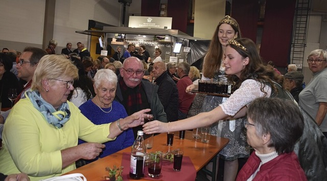 Die Hoheiten verteilen Kostproben des frisch gezapften Weins.  | Foto: Roland Vitt