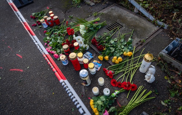 Passanten legen an der Unfallstelle Blumen und Kerzen ab.  | Foto: Christoph Schmidt (dpa)