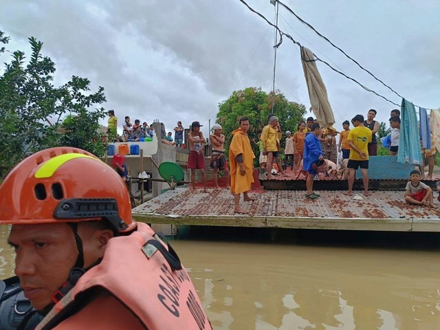 Viele mussten lange auf ihren D&auml;chern ausharren, bis Helfer sie erreichten.  | Foto: Uncredited/Philippine Coast Guard/AP/dpa