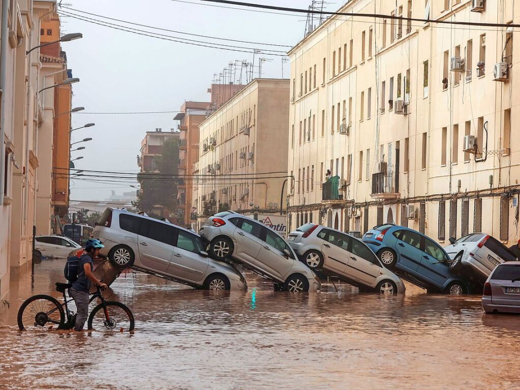 Valencia: Fahrzeugwracks sind auf der berschwemmten Strae aufeinander gestappelt,