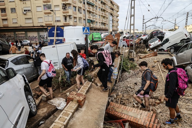 Spanien, Aldaia: Personen zwischen zer... Fuwegen und aufgetrmten Fahrzeugen.  | Foto: dpa