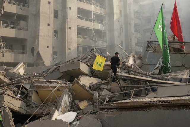 Ein Mann trgt eine Hisbollah-Fahne, w...eh, der Hochburg der Hisbollah, luft.  | Foto: Hassan Ammar (dpa)