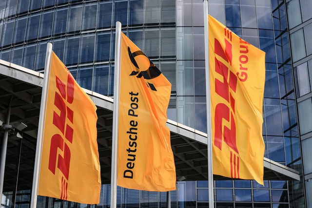 Fahnen wehen vor der Zentrale der DHL ...riefgesch&auml;ft Deutsche Post nennt.  | Foto: Oliver Berg/dpa