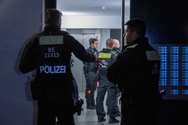 Polizisten stehen vor einem Mehrfamili...n des Verdachts eines Ttungsdeliktes.  | Foto: Christophe Gateau (dpa)