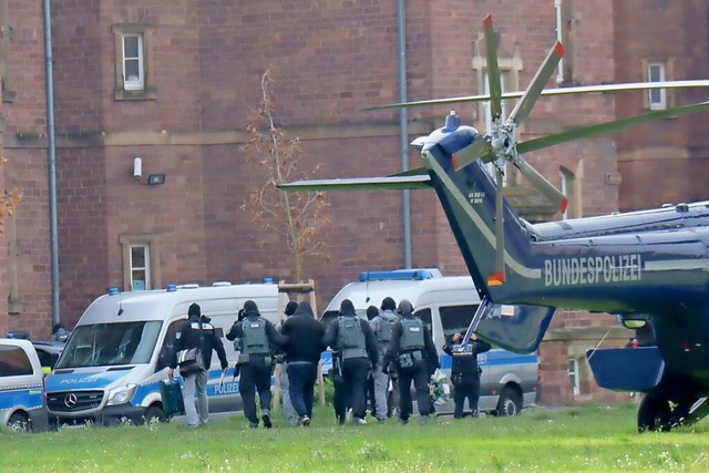 Polizisten bringen die bei der Razzia ...ber die Untersuchungshaft entscheidet.  | Foto: Rene Priebe (dpa)