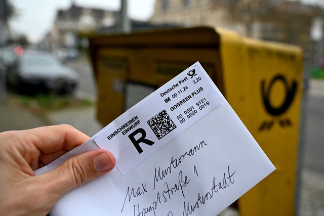 Ein Mann h&auml;lt ein sogenanntes Ein...r einen Briefkasten (gestellte Szene).  | Foto: Wolf von Dewitz/dpa