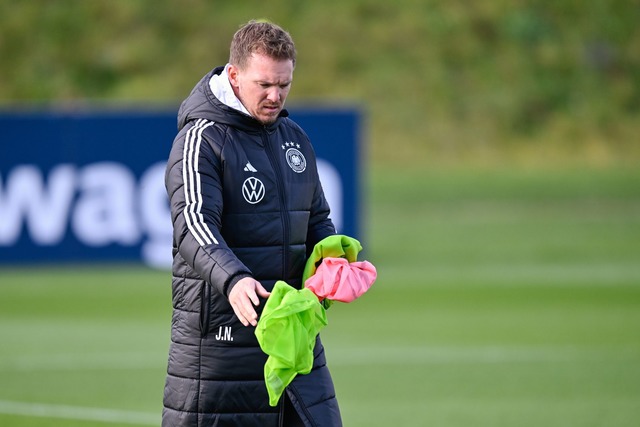 Bundestrainer Nagelsmann sortiert die Leibchen f&uuml;r das Training.  | Foto: Uwe Anspach/dpa