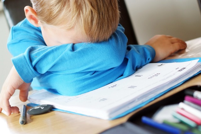 Ein kleiner Junge liegt erschpft auf dem Tisch.  | Foto: pegbes  (stock.adobe.com)