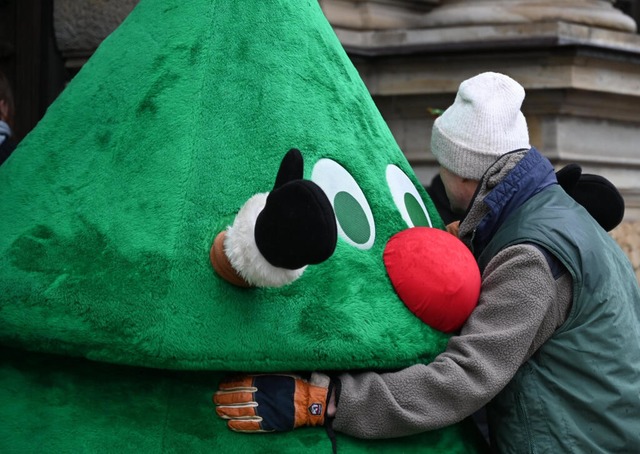 Der Angeklagte umarmt vor dem Strafjus... Person in einem Weihnachtsbaumkostm.  | Foto: Niklas Graeber (dpa)