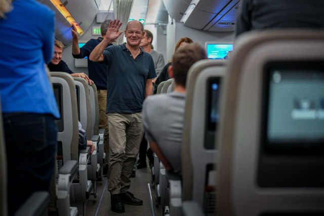 Ein Winken vom Kanzler auf dem R&uuml;ckflug aus Brasilien.  | Foto: Kay Nietfeld/dpa