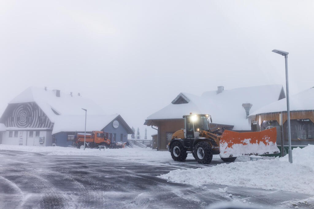 Rumfahrzeuge befreien einen Parkplatz an der Feldberger Passhhe vom Schnee.