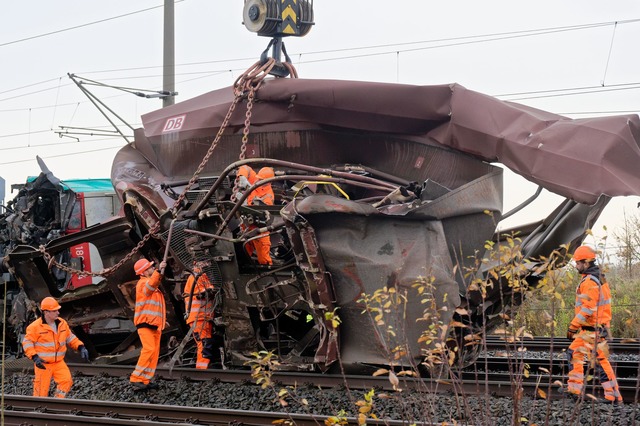 Arbeiter befestigen den demolierten G&uuml;terwaggon an einem Kran.  | Foto: Henning Kaiser/dpa