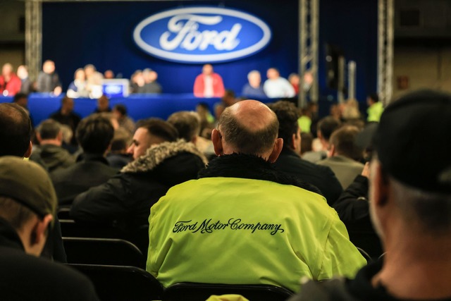 Ford-Mitarbeiter warten auf den Beginn der Betriebsversammlung.  | Foto: Oliver Berg/dpa