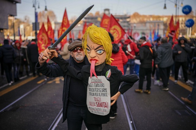 Ein Gewerkschafter h&auml;lt eine Pupp...entin Giorgia Meloni in die H&ouml;he.  | Foto: Marco Alpozzi/LaPresse/AP/dpa