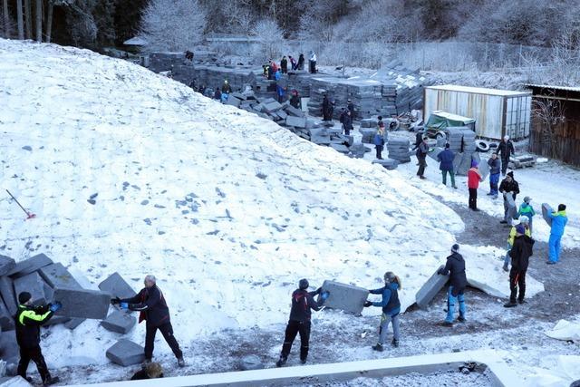 Menschenkette packt Schnee aus dem letzten Winter an der Hochfirstschanze in Titisee-Neustadt aus