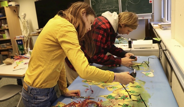 Davina und FSJ-ler Joshua gestalten ein buntes Plakat fr den Adventsmarkt.  | Foto: Martha Weishaar