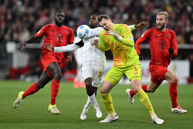 Manuel Neuer kommt zu sp&auml;t und rammt Leverkusens Jeremie Frimpong um.  | Foto: Sven Hoppe/dpa