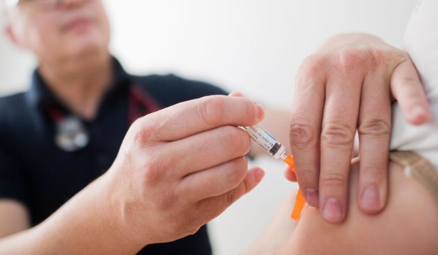 Ein Kinderarzt impft ein Kind gegen Polio.  | Foto: Julian Stratenschulte (dpa)