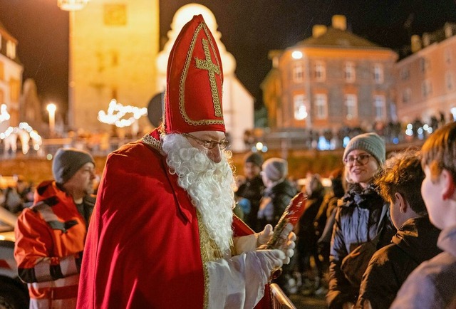 Ein Nikolaus verschenkt Schokonikoluse an Kinder.  | Foto: Harald Tittel (dpa)