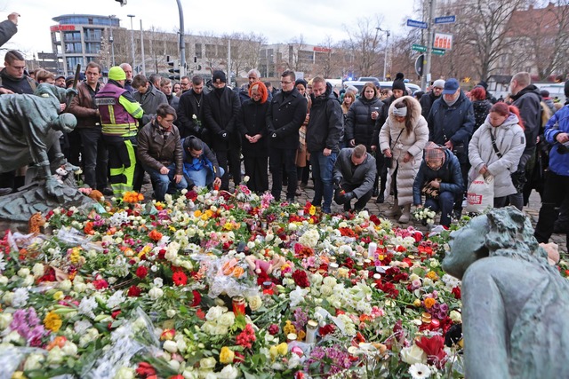 Menschen gedenken der Opfer und Verletzten nach der Todesfahrt.  | Foto: Matthias Bein/dpa