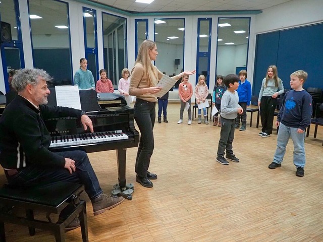 Pfarrerin Antonia Klumbies (Mitte) gib...des Kinderchors im Hintergrund wartet.  | Foto: Boris Burkhardt