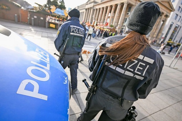 Zwei Polizisten stehen am Mittag auf e...ie Sicherheitsvorkehrungen verschrft.  | Foto: Marius Bulling (dpa)