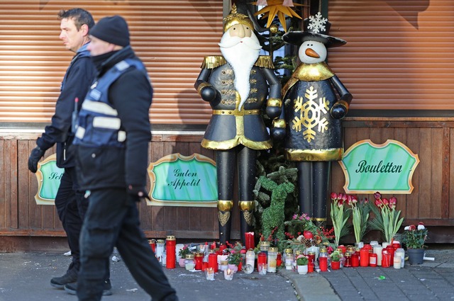 Auch vor den geschlossenen Weihnachtsmarkt-Buden legten Trauernde Blumen ab.  | Foto: Matthias Bein/dpa