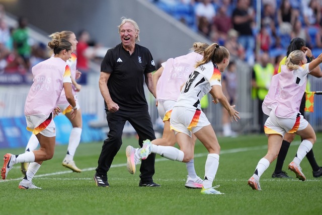 Jubel &uuml;ber Olympia-Bronze: Horst Hrubesch und die Nationalspielerinnen.  | Foto: Marcus Brandt/dpa