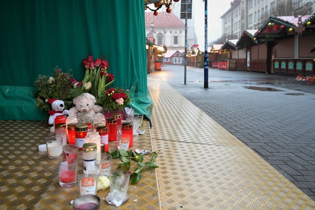 Menschen haben Blumen, Kerzen und Pl&uuml;schtiere niedergelegt.  | Foto: Heiko Rebsch/dpa