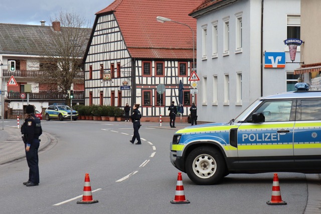 Polizeibeamte sichern die Stra&szlig;e rund um die Bankfiliale.  | Foto: Ren&eacute; Priebe/PR-Video/dpa