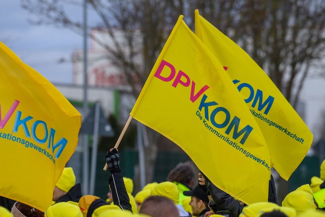 Warnstreikende schwenken vor dem DHL P... zu Warnstreiks im Raum Karlsruhe auf.  | Foto: Klaus-Dietmar Gabbert/dpa