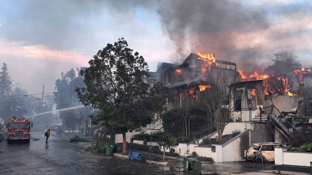 Feuerwehrleute arbeiten in Los Angeles daran, einen Hausbrand zu l&ouml;schen.  | Foto: Damian Dovarganes/AP/dpa