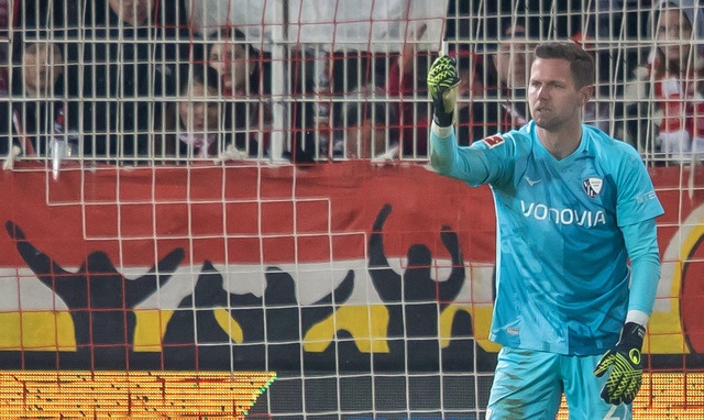 Bochums Keeper Patrick Drewes das Feuerzeug hoch, das ihn getroffen hat.  | Foto: Andreas Gora/dpa