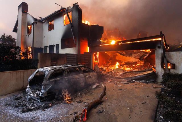 Ein verbranntes Auto parkt vor einem a...es zweiten Tages des Palisades-Feuers.  | Foto: Jonathan Alcorn (dpa)