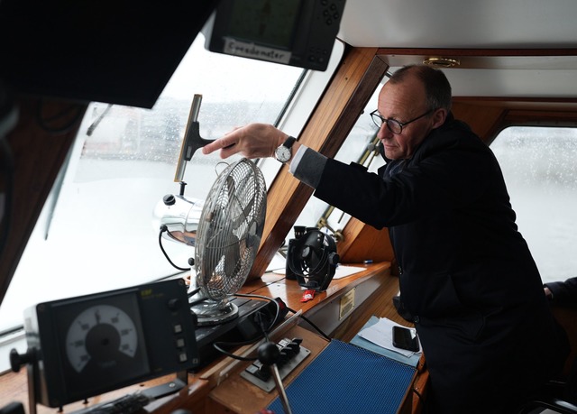 Scheibenwischer: Friedrich Merz, Kanzl...er Barkasse im Hamburger Hafen sauber.  | Foto: Marcus Brandt/dpa Pool/dpa