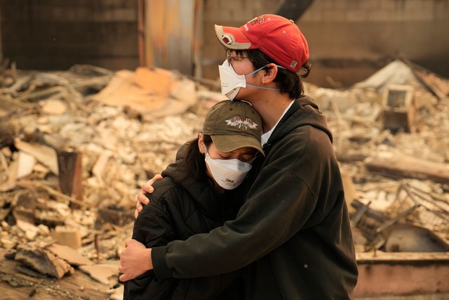 Ari Rivera (r) und Anderson Hao umarme...ben ihr gesamtes Hab und Gut verloren.  | Foto: John Locher/AP/dpa