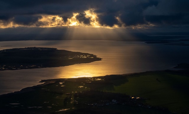 Die Sonne geht hinter Wolken &uuml;ber der Insel R&uuml;gen unter.  | Foto: Stefan Sauer/dpa/ZB