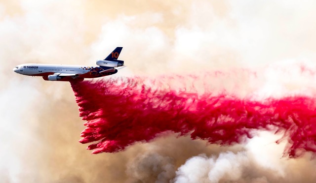 Ein Flugzeug wirft L&ouml;schmittel &u...m Mandeville Canyon in Los Angeles ab.  | Foto: Brian Cahn/ZUMA Press Wire/dpa