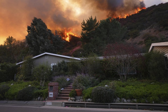 Das Palisades-Feuer brennt oberhalb eines Hauses im Mandeville Canyon.  | Foto: Eric Thayer (dpa)