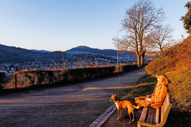 Klarer Himmel ber Freiburg: Eine Frau...uf einer Parkbank auf dem Schlossberg.  | Foto: Philipp von Ditfurth (dpa)