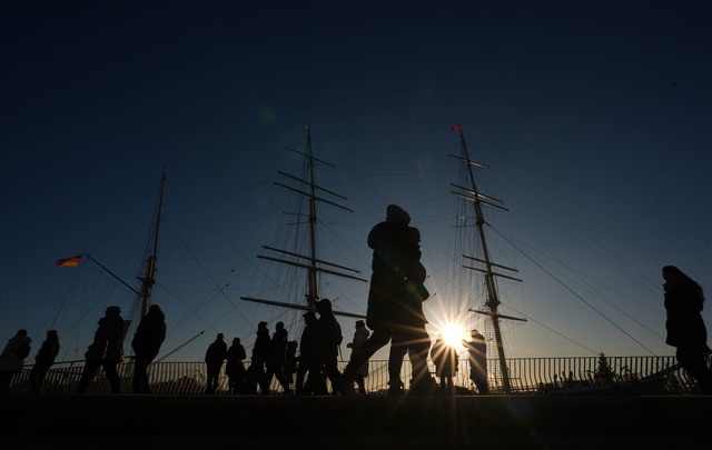 Passanten genie&szlig;en das sonnige W...n-Fedder-Promenade im Hamburger Hafen.  | Foto: Marcus Brandt/dpa