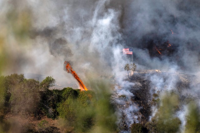 Eine amerikanische Flagge weht &uuml;ber einem Teil des Mandeville Canyon  | Foto: Mark Edward Harris/ZUMA Press Wire/dpa