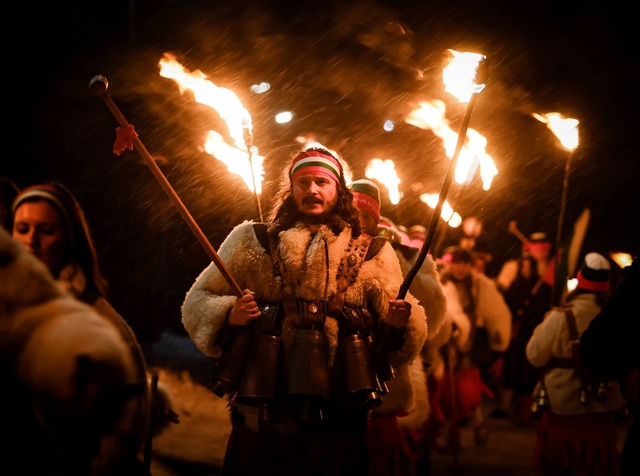 Bulgarische Kukeri-T&auml;nzer halten ihre Fackeln beim Neujahrsritual Surva.  | Foto: Valentina Petrova/AP/dpa